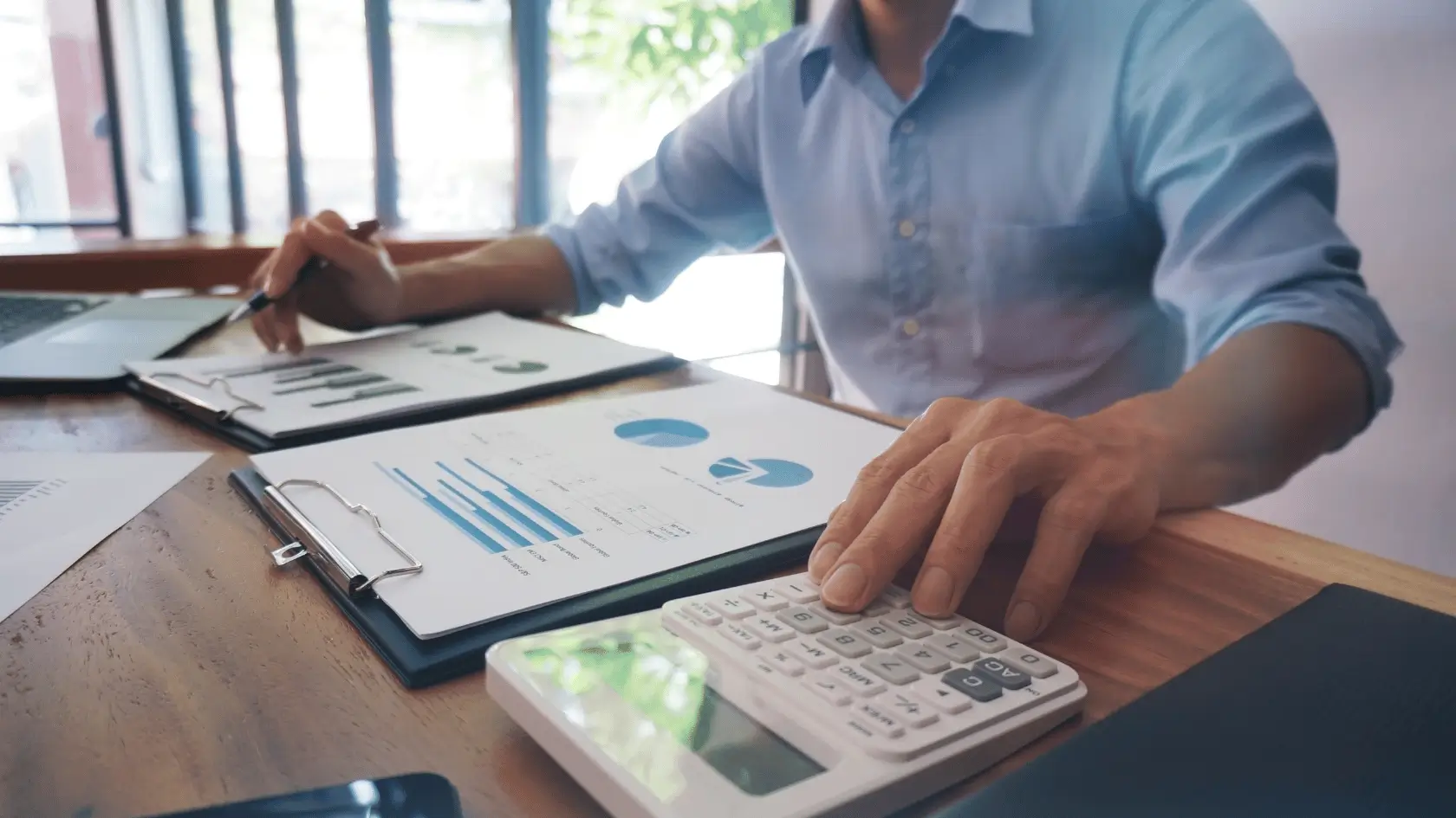 Financial professional reviewing a structured financial blueprint with charts and reports