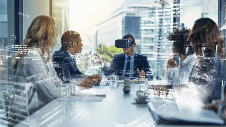 Five people in business attire sit around a conference table in a modern office. One person is wearing a virtual reality headset. The scene has a digital, futuristic overlay effect.