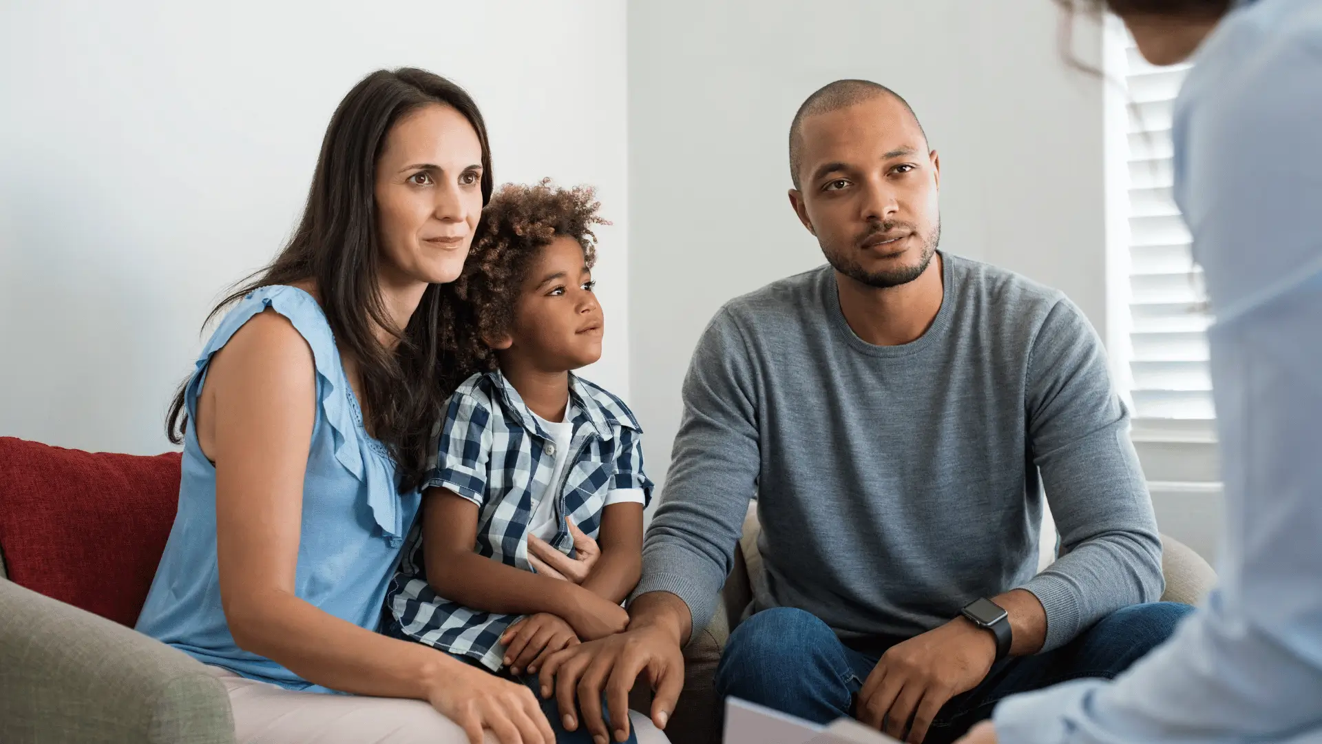 Young interracial family attentively listening to financial advisor during home consultation