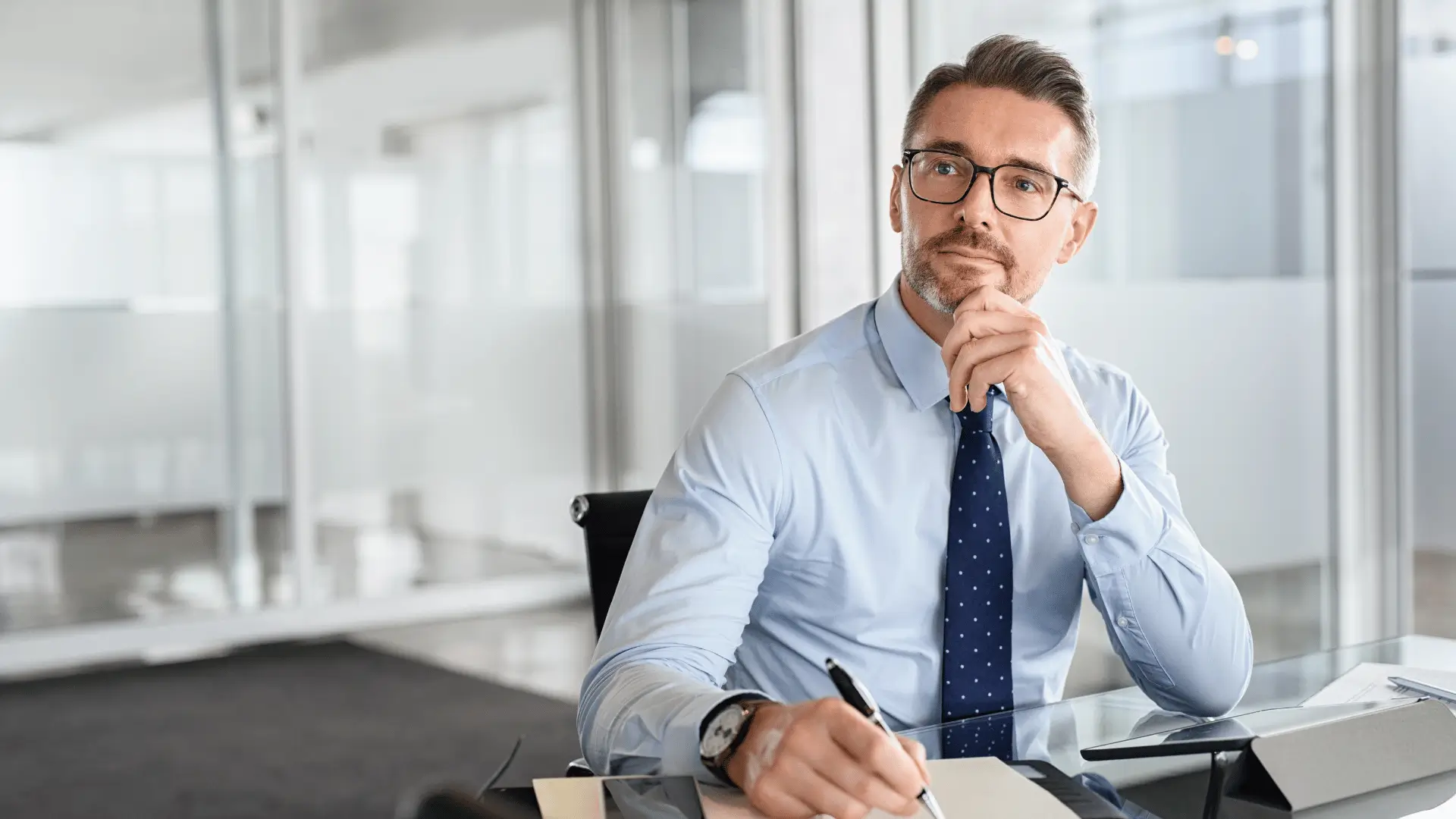 Executive business owner thinking strategically in modern glass-walled office