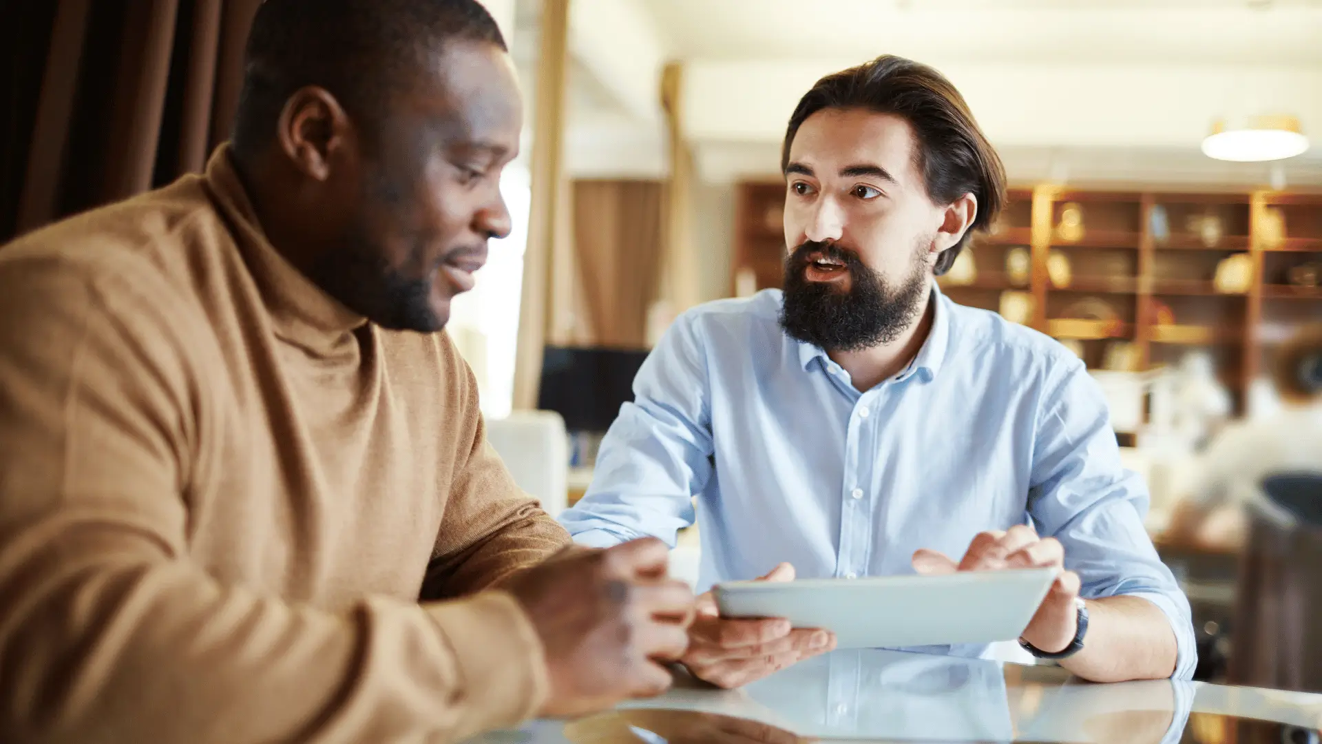 Two professionals sharing ideas and reviewing content together in warm casual setting